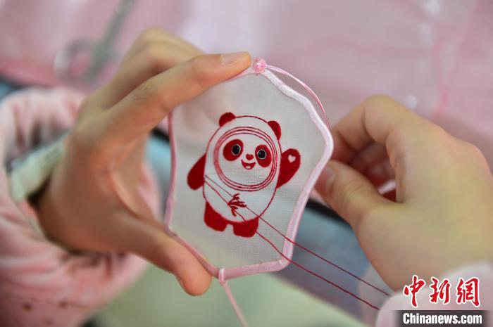 圖為一名小學(xué)生正在繡制2022年北京冬奧會(huì)吉祥物“冰墩墩”形象。　喻云亮 攝