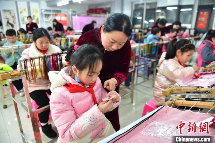 江西省級(jí)非遺豫章繡傳承人手把手指導(dǎo)小學(xué)生繡制2022年北京冬奧會(huì)吉祥物“冰墩墩”形象?！∮髟屏?攝