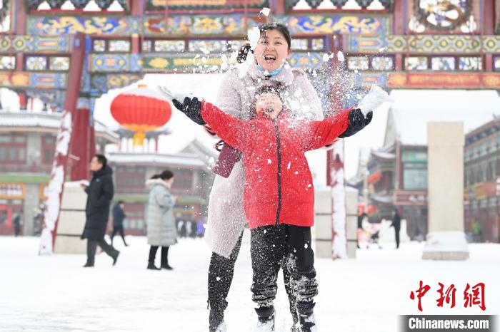 2月13日，家長與小朋友在呼和浩特市大召廣場享雪趣?！⑽娜A 攝