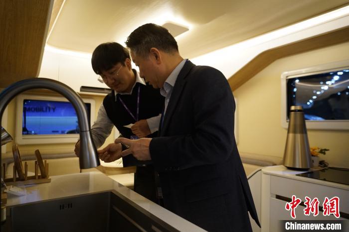 圖為參展商向觀眾介紹房車內(nèi)部設(shè)計(jì)?！⑿?攝