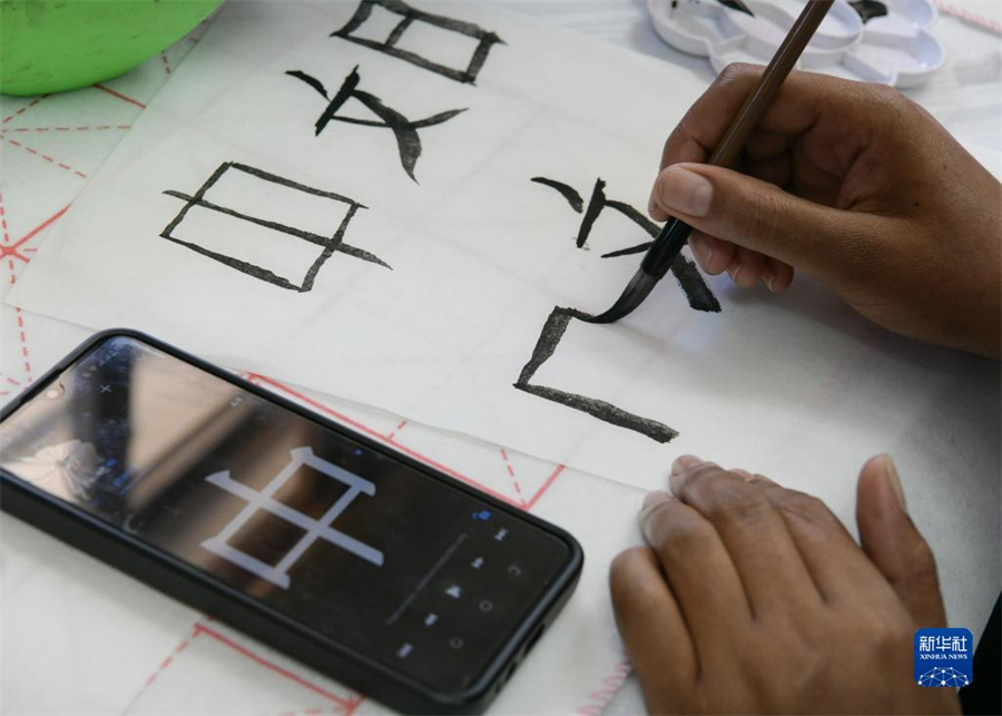 4月18日，肯尼亞學(xué)生在內(nèi)羅畢大學(xué)孔子學(xué)院舉辦的活動(dòng)上寫毛筆字?？夏醽唭?nèi)羅畢大學(xué)孔子學(xué)院18日舉辦“中文，增進(jìn)文明對(duì)話”主題活動(dòng)，慶祝即將到來(lái)的第14個(gè)聯(lián)合國(guó)中文日?？夏醽唽W(xué)生參與互動(dòng)，進(jìn)行書法、剪紙、唱中文歌等活動(dòng)。新華社記者 韓旭 攝