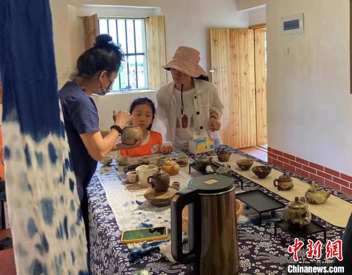 圖為：游客正在咨詢臺(tái)灣柴燒作品。　葉秋云 攝