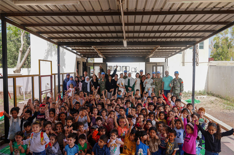 當(dāng)?shù)貢r(shí)間5月30日，黎巴嫩南部庫(kù)雷拉公立小學(xué)，“六一”國(guó)際兒童節(jié)前夕，中國(guó)第21批赴黎維和多功能工兵分隊(duì)官兵看望慰問(wèn)學(xué)校師生，并開(kāi)展文化交流活動(dòng)，圖為我維和官兵同師生合影。李竹林?jǐn)z