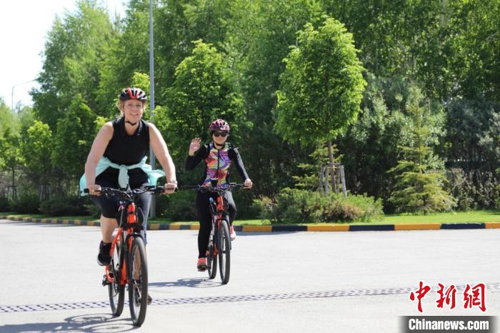 亞信副秘書長遲方(右一)與聯合國駐哈協(xié)調員在騎行活動中。　亞信秘書處供圖