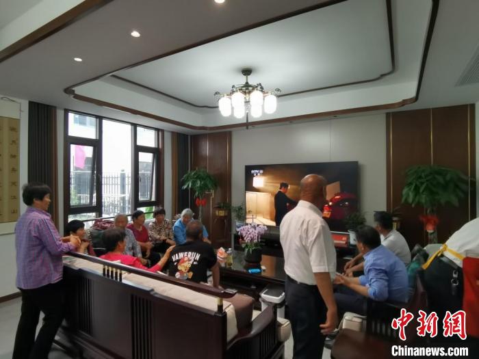 親友們集中在費(fèi)俊龍家中觀看返程的視頻?！＄娚?攝