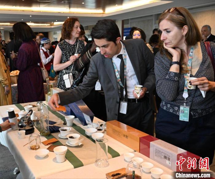 現(xiàn)場觀眾觀看中國展臺茶藝表演、了解茶文化。　靖樹 攝