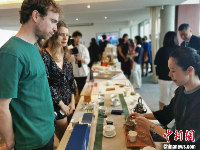 現(xiàn)場觀眾觀看中國展臺茶藝表演、了解茶文化。　靖樹 攝