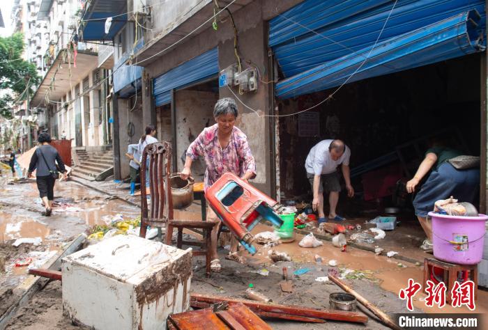 7月4日，萬州區(qū)五橋街道，洪水退去后，居民搶救生活物資?！∪矫宪?攝