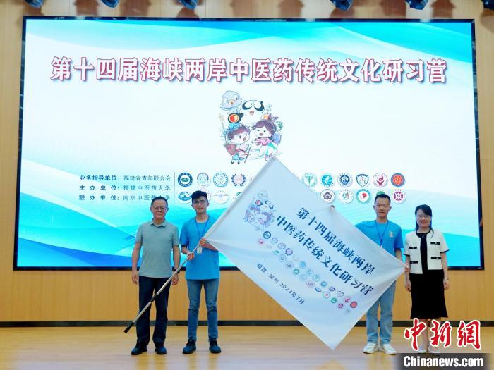 共青團(tuán)福建省委副書記吳雪(右一)、福建中醫(yī)藥大學(xué)黨委副書記林羽(左一)為兩岸學(xué)生代表頒授營(yíng)旗?！≡S燁婷 攝