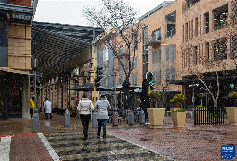 7月10日，在南非約翰內(nèi)斯堡一處商業(yè)區(qū)，人們在雪中行走。新華社記者 張譽(yù)東 攝