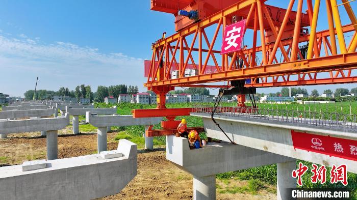 長25米重80噸的箱梁平穩(wěn)、精準(zhǔn)地落在S314分離式立交橋25號和26號墩上。　劉玉才 攝