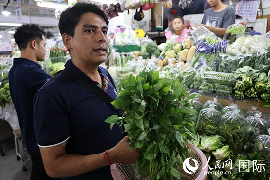 7月19日，泰國曼谷藍(lán)象餐廳員工向參加活動(dòng)的多國代表介紹如何挑選新鮮蔬菜。 人民網(wǎng)記者 張矜若攝