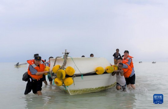 7月21日，中國海軍“和平方舟”號醫(yī)院船醫(yī)護(hù)人員涉水登島，前往基里巴斯一診療點(diǎn)。新華社記者 黎云 攝