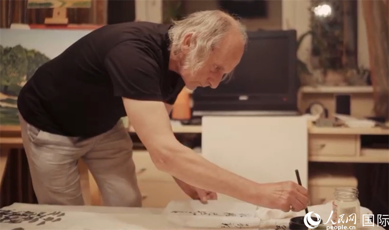 伊戈?duì)枴げ紶枛|諾夫在畫作上題詞。人民網(wǎng)記者 馬天翼攝