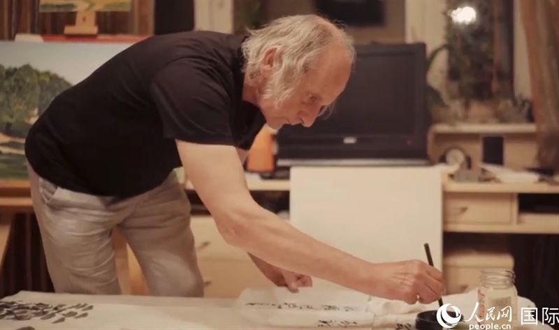 伊戈爾·布爾東諾夫在畫作上題詞。人民網記者 馬天翼攝