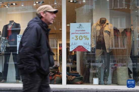   10月31日，一名男子從比利時布魯塞爾一家貼有打折信息的店鋪前走過。新華社記者 趙丁喆 攝