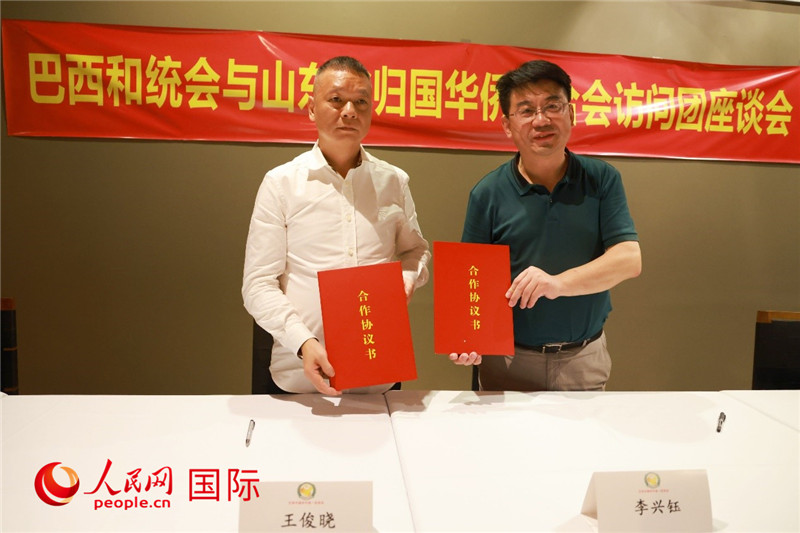 中國僑聯(lián)副主席、山東省僑聯(lián)主席李興鈺（右）與巴西和統(tǒng)會會長王俊曉簽署合作協(xié)議書。人民網(wǎng)記者 陳海琪攝