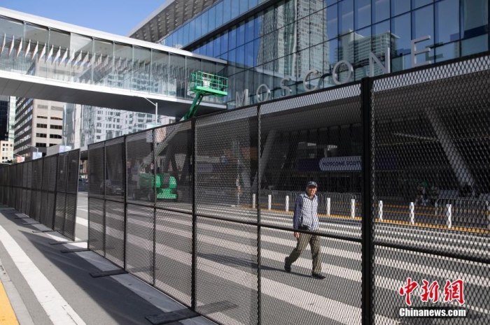 當?shù)貢r間11月10日，一名行人從美國舊金山莫斯康中心周圍的金屬圍欄旁經(jīng)過。隨著亞太經(jīng)合組織(APEC)第三十次領(lǐng)導人非正式會議臨近，作為會議場地的莫斯康中心附近出現(xiàn)金屬圍欄，執(zhí)勤警察也大幅增加。<a target='_blank' href='/'><p  align=