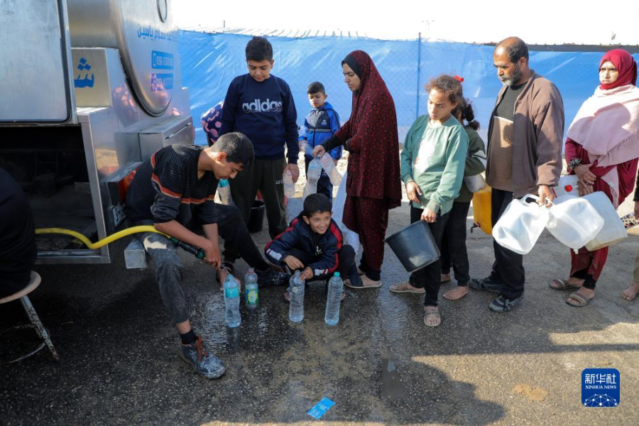 12月8日，在加沙地帶南部城市拉法一處臨時營地內，人們排隊打水。新華社發(fā)（里澤克·阿卜杜勒賈瓦德 攝）