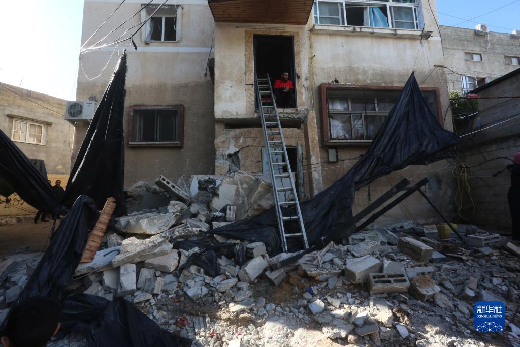 12月17日，在約旦河西岸城市圖勒凱爾姆附近的一處難民營，人們查看在沖突中損毀的房屋。新華社發(fā)（尼達爾·艾仕塔耶攝）