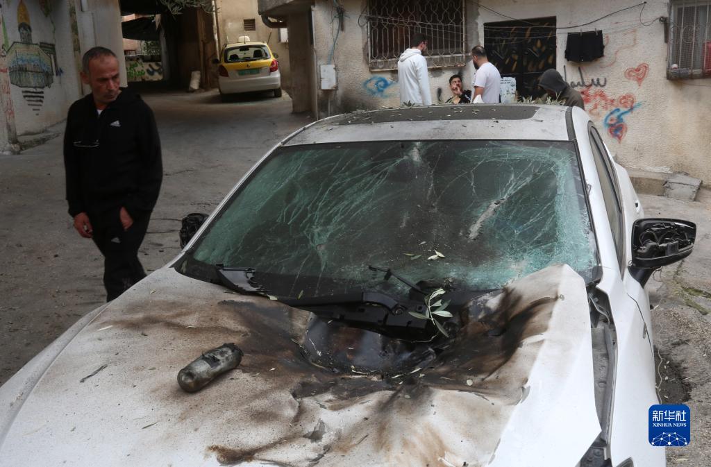 12月17日，在約旦河西岸城市圖勒凱爾姆附近的一處難民營，人們查看在沖突中損毀的車輛。新華社發(fā)（尼達爾·艾仕塔耶攝）