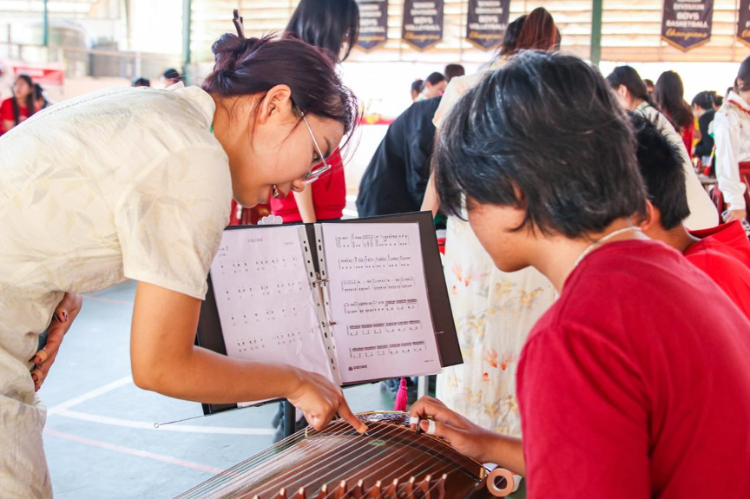 志愿者教師指導(dǎo)學(xué)生彈奏古箏?；顒?dòng)主辦方供圖