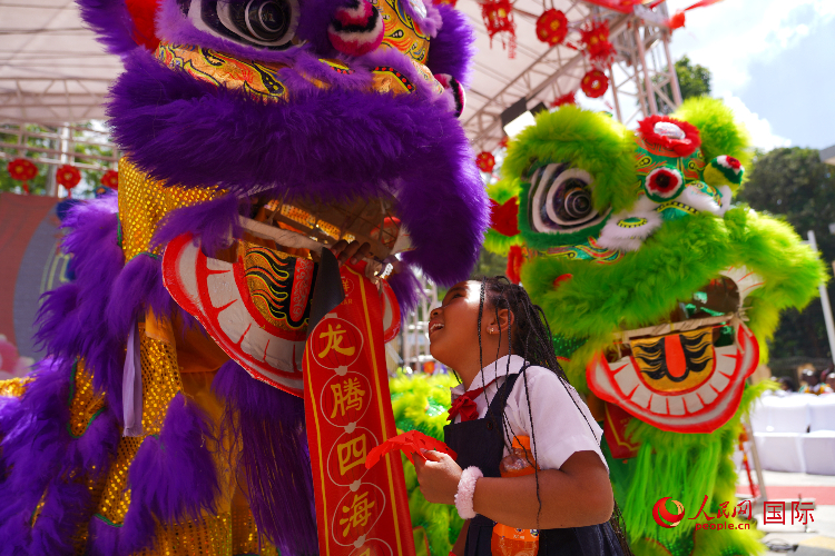 小朋友與舞獅表演者互動(dòng)。人民網(wǎng)記者 黃煒鑫攝