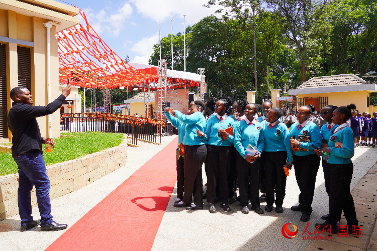 一名老師在給學(xué)生拍照留念。人民網(wǎng)記者 黃煒鑫攝