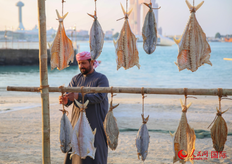    手工藝者展示如何晾曬魚干。人民網(wǎng) 塔里克·易卜拉欣攝