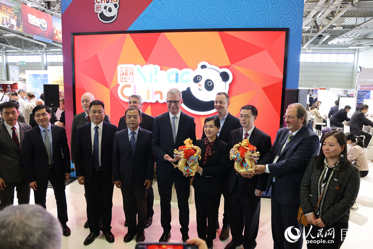 參加中國館開幕式的嘉賓們在“你好 中國” 展臺前合影留念。