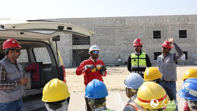 穆薩瓦爾(圖中紅衣人）現(xiàn)場(chǎng)演示工具操作規(guī)范。人民網(wǎng)記者 管克江攝