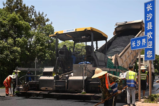 工人正在進(jìn)行“極薄磨耗層”路面的鋪筑。受訪單位供圖