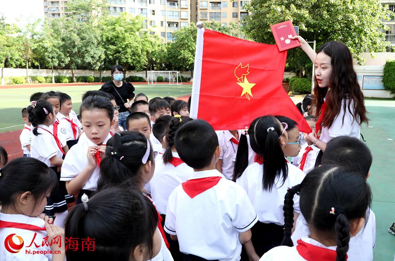 老師向少先隊員展示隊旗。人民網(wǎng) 符武平攝