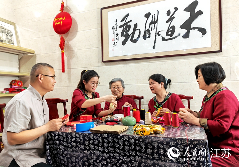 王秀英老人指導(dǎo)孫女制作香包。人民網(wǎng) 閆峰攝