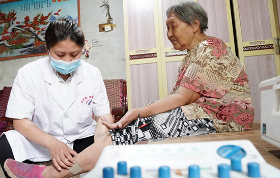 護理團隊醫(yī)生為老人進行低頻功能康復。陳佳兵攝