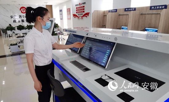 工作人員介紹自助系統的功能和使用方法。人民網 胡雨松攝