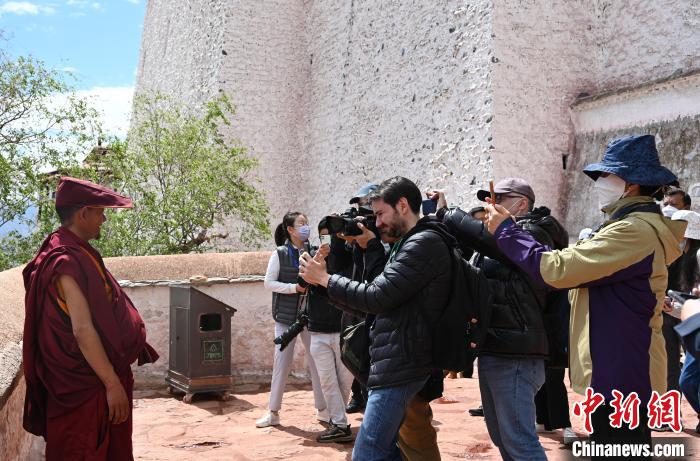 圖為中外媒體拍攝朝拜布達拉宮的僧人?！≮w朗 攝