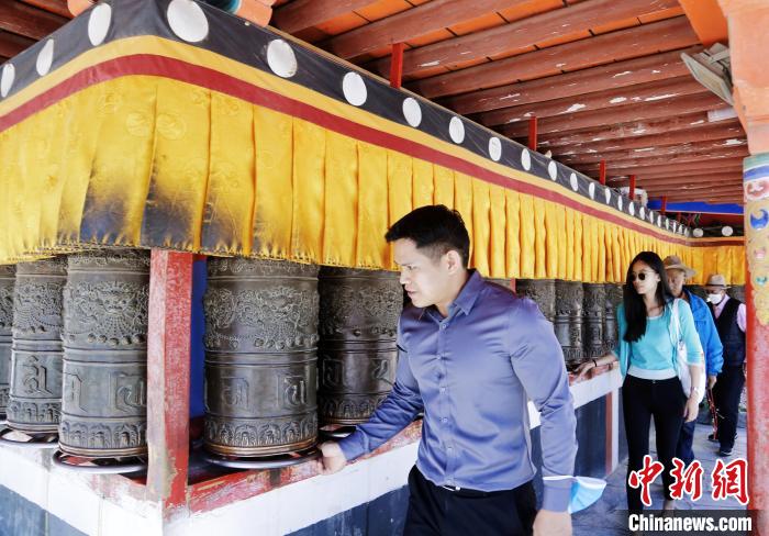 圖為外籍嘉賓體驗(yàn)藏族傳統(tǒng)轉(zhuǎn)經(jīng)筒?！●R銘言 攝