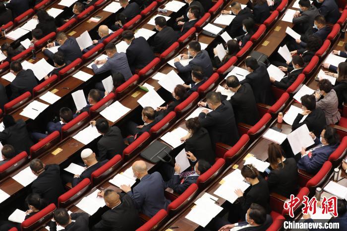 圖為會議現(xiàn)場，參會代表正在聽取政府工作報告?！∑钤鲚?攝