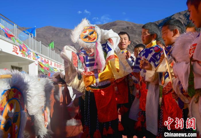 圖為加查縣安繞鎮(zhèn)小學學生在試穿藏戲面具?！∝暩聛硭?攝