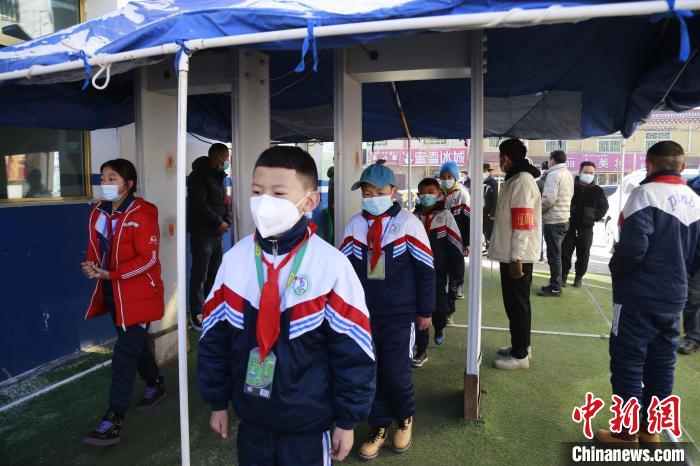 圖為學(xué)生測(cè)量體溫后進(jìn)入校園?！●R銘言 攝