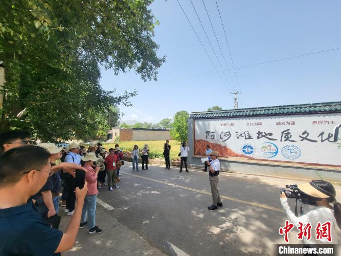 圖為中國地質(zhì)大學(xué)(北京)教授張緒教介紹村落情況?！『衍?攝