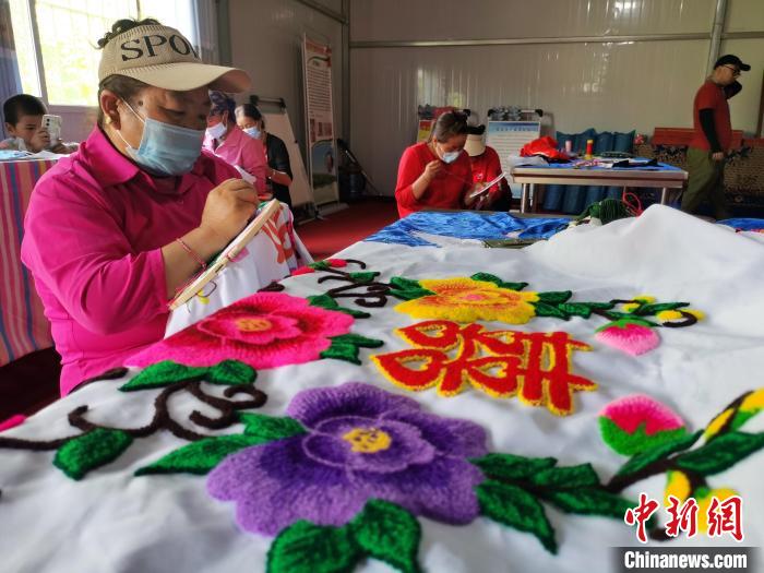 圖為婦女制作青繡?！?zhí)砀?攝