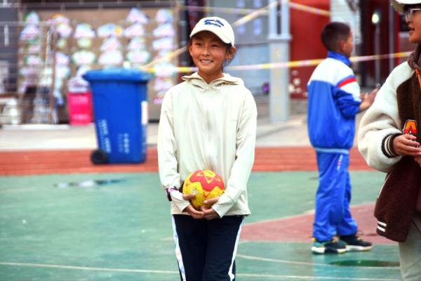 在高原上教孩子們打手球，“慢慢兒來，甭著急！”