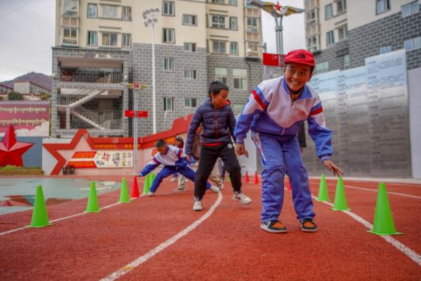 在高原上教孩子們打手球，“慢慢兒來，甭著急！”