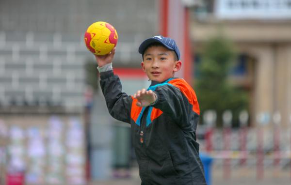 在高原上教孩子們打手球，“慢慢兒來，甭著急！”