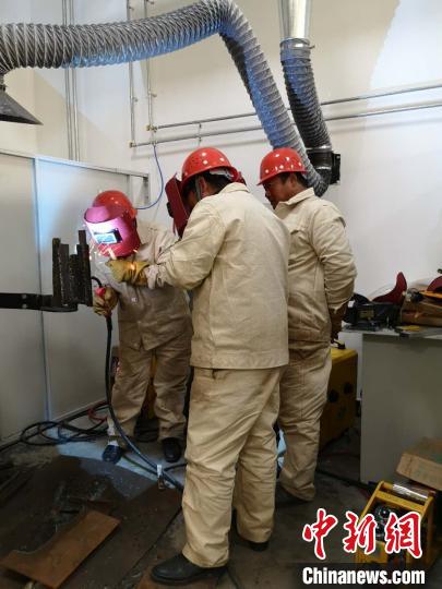 圖為學(xué)員正在進行電焊技能學(xué)習?！》尔惙?攝