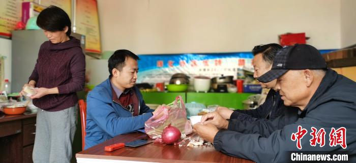 圖為扶貧路上“臨時(shí)一家人”準(zhǔn)備午餐?！∥航ㄜ?攝