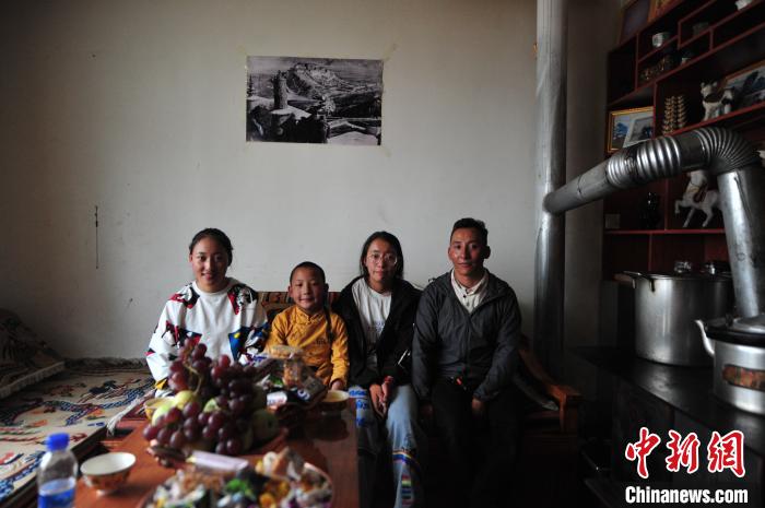 圖為8月12日，2018年7月從距那曲市色尼區(qū)城區(qū)那曲鎮(zhèn)90千米外的古露鎮(zhèn)當(dāng)桑村搬遷至城區(qū)的旦增(右一)與家人在80多平方米的新家合影(資料圖)?！垈?攝
