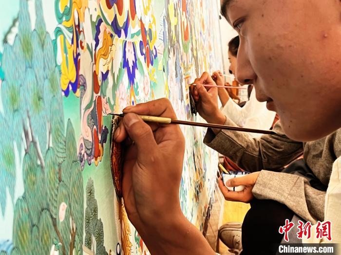 圖為畫(huà)師繪畫(huà)唐卡。　馬文莉 供圖